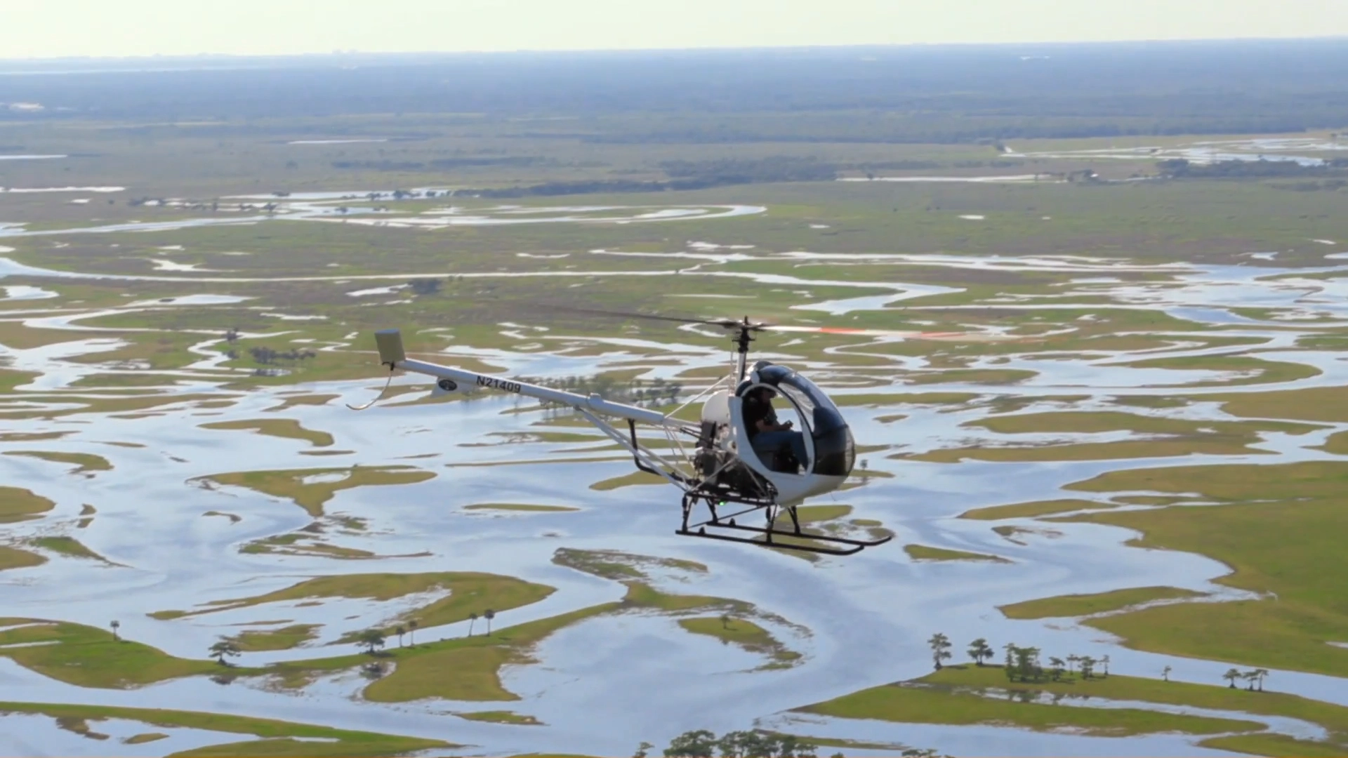 White helicopter performing training maneuvers with FAA-certified flight instructor at USATS